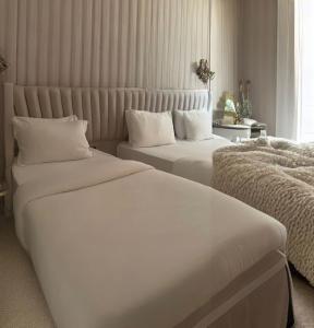 ArnavutköyThe Queen Airport Hotel的配有白色床单的酒店客房内的两张床
