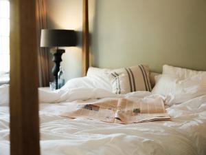 Coln Saint Aldwyn力推考林新酒店的一间卧室配有一张床铺,上面有报纸