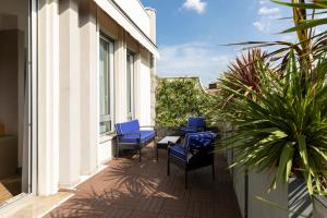 米兰亚特兰迪克C酒店的阳台设有带蓝色椅子和桌子的庭院。