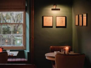 Coln Saint Aldwyn力推考林新酒店的一间带桌子和窗户的用餐室