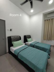 彭亨V-Homestay Bentong的配有绿色枕头的客房内的两张床