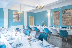 大雷申格罗斯雷申希酒店的一间设有白色桌椅和蓝色墙壁的客房