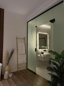 哈伊勒شاليه اند هوم的浴室设有玻璃门、水槽和镜子