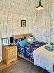 DrybrookHoliday Lodges with hot tub & Cosy Cabins - Greenway Farm, Drybrook, Forest of Dean的一间卧室配有一张床和一个床头柜