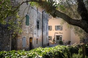 斯维特温斯纳特Della Croce Bed&Breakfast的一座古老的石头建筑,前面有一棵树