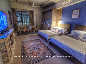 塞贝维Tamarind Suites OR Domain NeoCyber, click room first for pics的酒店客房设有两张床和电视。