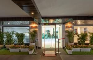 新德里阿斯坦萨诺瓦门廊酒店的种植盆栽植物的办公楼入口