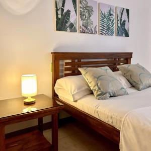 达古潘JORA Studio Apartment 1-B的一间卧室配有一张床和一张带台灯的桌子