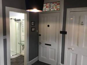 罗撒西Bellevue Bute, Luxury 2 bedroom sea view flat的浴室设有白色门和步入式淋浴间。