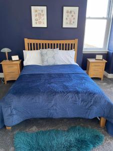 罗撒西Bellevue Bute, Luxury 2 bedroom sea view flat的蓝色的床、蓝色的被子和2个窗户