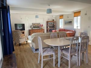 威尔汉姆Cottages at Woodlands, Appleloft的客厅配有桌椅和沙发