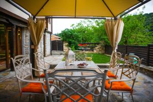 大特尔诺沃Veliko Tarnovo Villa Lora的庭院内桌椅和遮阳伞