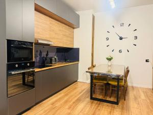 阿拉木图Infinity Estate Atameken的厨房配有桌子和墙上的时钟