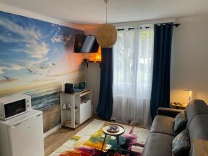 特里尼亚克Chambre Privée chez L' Habitant的客厅配有沙发和海洋绘画