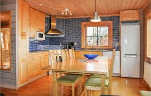 萨伦6 Bedroom Gorgeous Apartment In Slen的厨房配有木桌和冰箱。