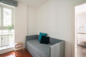 米兰Isola Milano apartment的客厅配有带蓝色枕头的灰色沙发