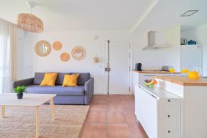 托雷德本纳贾尔邦Apartamento en Benagalbón con terraza by Alterhome的一间带蓝色沙发的客厅和一间厨房