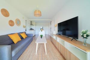 托雷德本纳贾尔邦Apartamento en Benagalbón con terraza by Alterhome的客厅配有蓝色的沙发和平面电视。