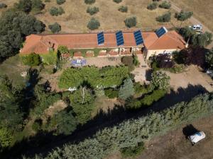 AldeaquemadaHotel Rural La Cimbarra的享有房子的空中景色,上面设有太阳能电池板