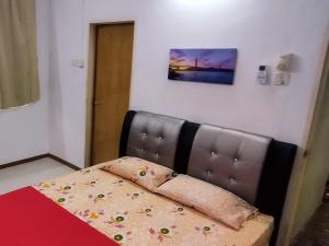 峇都丁宜Pinang Beach Home @ Ferringhi的一间卧室配有一张带皮革床头板的床
