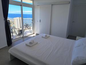 美洲海滩Panoramic Floor - Las Americas的一间带白色床的卧室和一个阳台
