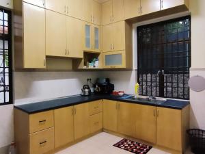 峇都丁宜Pinang Beach Home @ Ferringhi的厨房配有黄色橱柜、水槽和窗户。