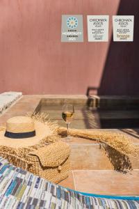阿索斯Chromata Assos Villas Kefalonia的一杯葡萄酒和一顶帽子在桌子上