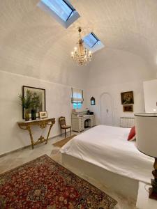 西迪·布·赛义德Si Brahim studio piscine, Sidi Bou Saïd的卧室配有白色的床和吊灯。