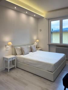 西尔米奥奈Villa Pensione Mercedes的白色的卧室设有一张大床和一个窗户