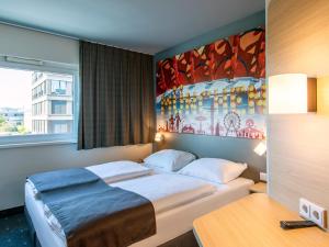 慕尼黑慕尼黑城西住宿加早餐酒店的卧室配有一张床,墙上挂有绘画作品