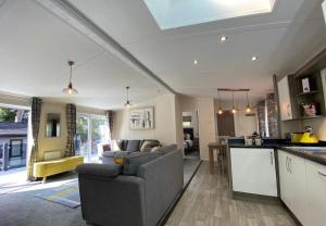 班戈SL06 - Idwal Lodge with Hot Tub的厨房以及带沙发和桌子的客厅。