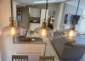 班戈SL06 - Idwal Lodge with Hot Tub的客厅配有3个玻璃吊灯和1张沙发