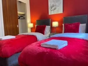 PrestonpansCoastal Apartment 2 Bedrooms, Sleeps upto 6, Free Parking的红色墙壁客房的两张床