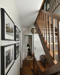 古维约Maison Eureka Chantilly Gouvieux的墙上挂着照片的房子里的楼梯