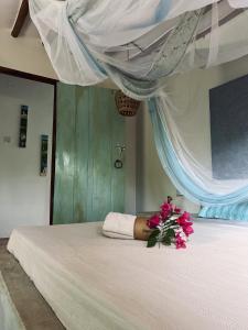 基济姆卡济Mawingu lodge的一间卧室,床上有粉红色的鲜花