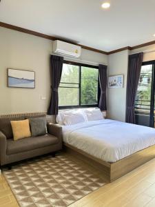 卡塔海滩Kata Noi Place floor3的一间卧室配有一张床、一张沙发和窗户。
