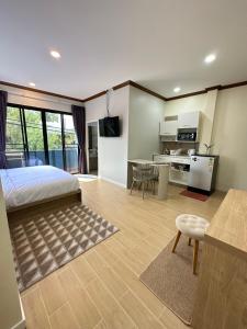 卡塔海滩Kata Noi Place floor3的一间卧室配有一张床、一间厨房和一张桌子