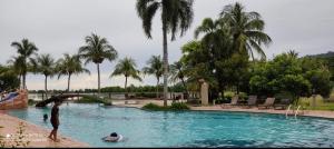 珍南海滩Villa Dalam Laut 580的一群人在棕榈树游泳池里