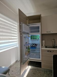 拉什科Apartmaji PR' KERIN的厨房里空着冰箱,门开