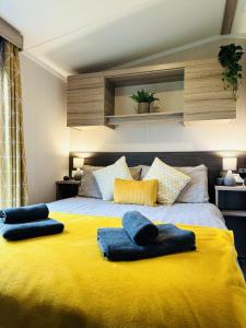 斯卡伯勒Adelfas的一张黄色的大床,上面有两条蓝色的毛巾