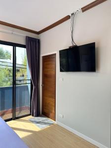 卡塔海滩Kata Noi Place floor3的卧室配有壁挂式平面电视。