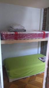 伊察Casa amoblada con cochera的配有绿色床垫的客房内的架子