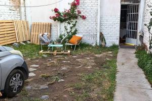 伊察Casa amoblada con cochera的房屋前设有带2把椅子和1张桌子的庭院。