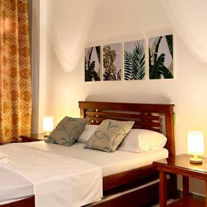 达古潘JORA Studio Apartment 1-C的一间卧室配有一张带两张桌子和两盏灯的床。