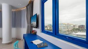 岘港Lucia Beach Hotel的窗户房间里一张蓝色的桌子
