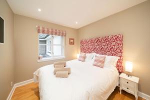 奥赫特拉德Strathallan - Luxury 3 Bedroom Apartment, Gleneagles, Auchterarder的一间卧室配有一张白色大床和红色床头板