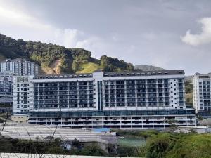 伯恩仓aparthotel cameron的一座白色的大建筑,背景是一座山