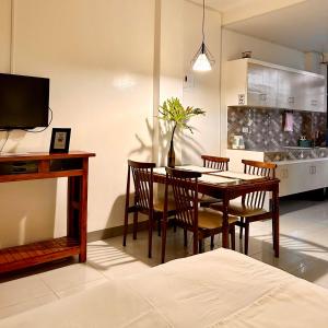 达古潘JORA Studio Apartment 1-C的厨房以及带桌椅的用餐室。