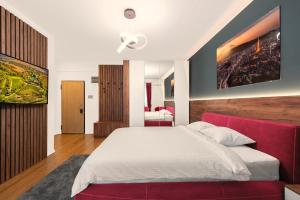 皮特什蒂Pitesti Residence的一间卧室配有一张大床和一张红色的沙发