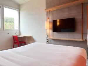 Saint-Christol-lès-Alès圣克里斯托尔莱萨勒宜必思快捷酒店的配有一张床和一台平面电视的酒店客房